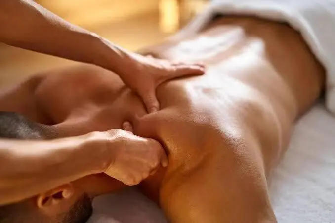 Therapist applying firm pressure to a guest's shoulder